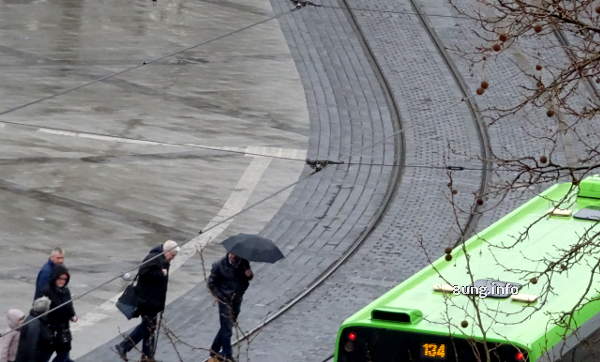 Passanten bei Regen und Wind auf dem Weg zur Strassenbahn