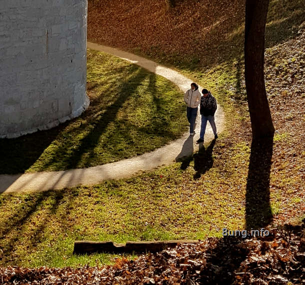 Spaziergänger und Bäume im Gegenlicht